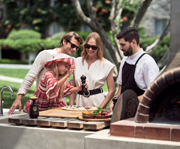 Family outdoor cooking experience with chef by the wood-fired oven at Eagles Resort